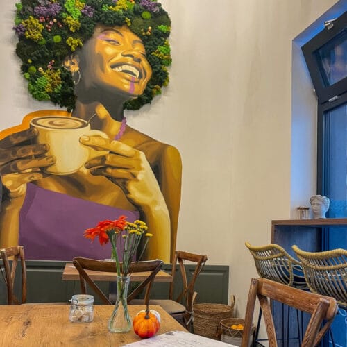 Falfestmény a Zuzu cafe&bakery belső terében, asztal friss virágokkal