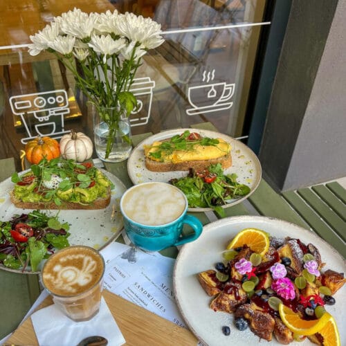 Brunch-asztal avokádós pirítóssal, latte-val és gyümölcsös desszerttel